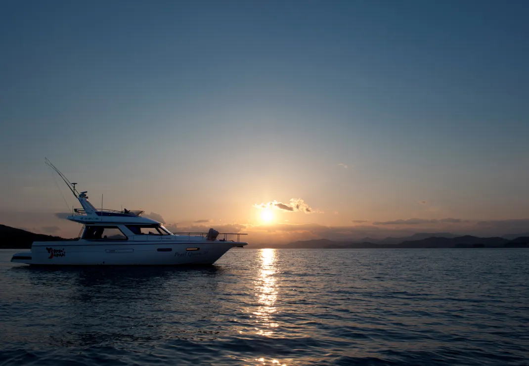 夕日とクルージングする船